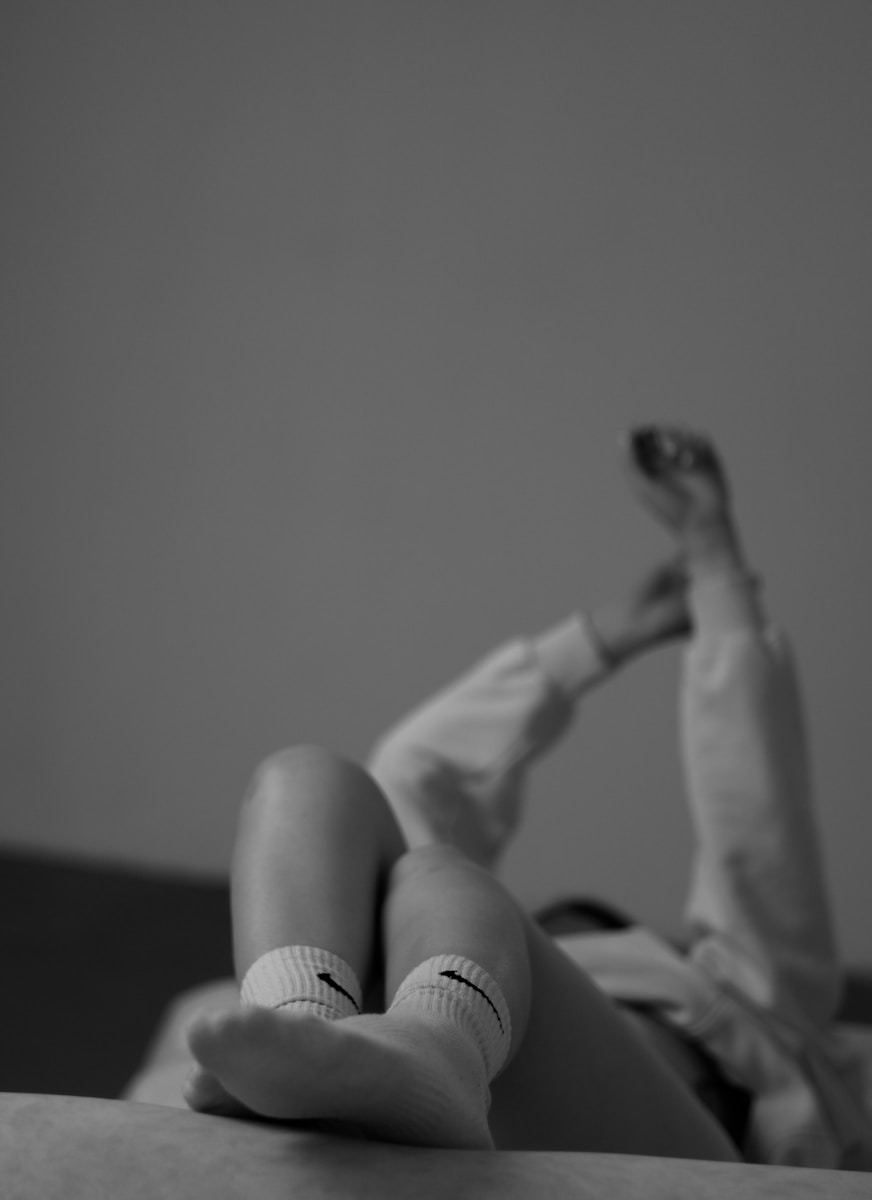a person laying on a bed with their feet up