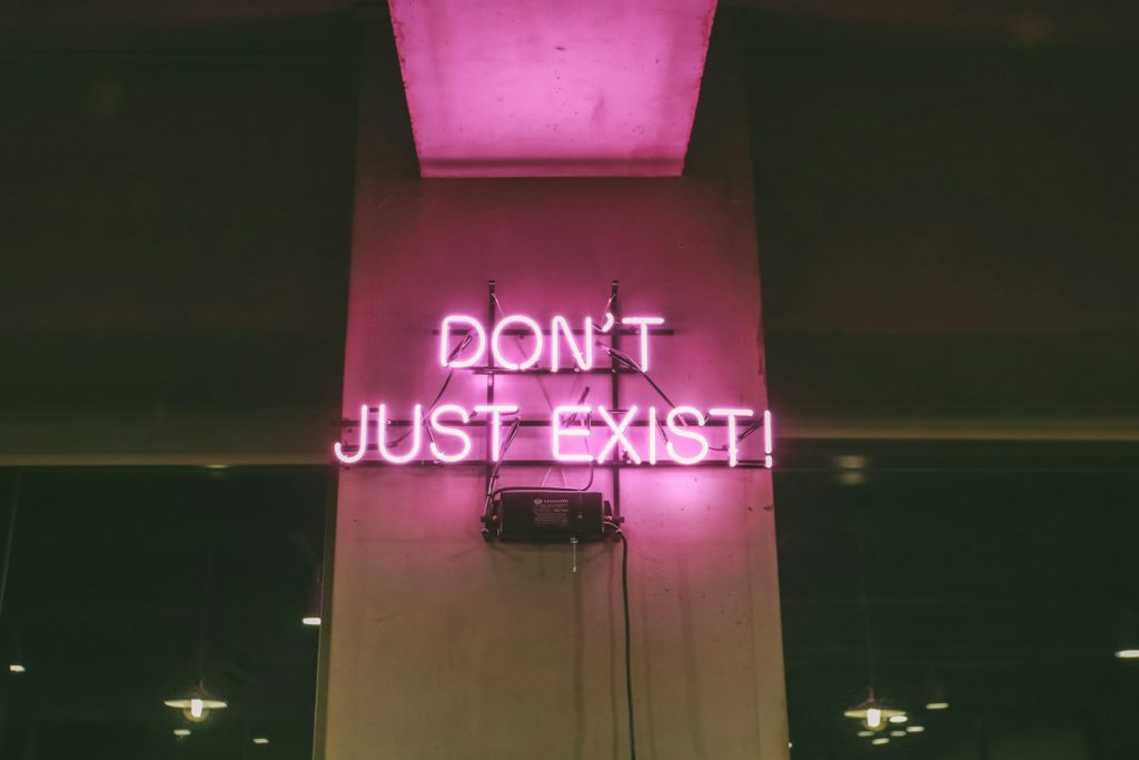 purple Don't Just Exist neon signage turned-on